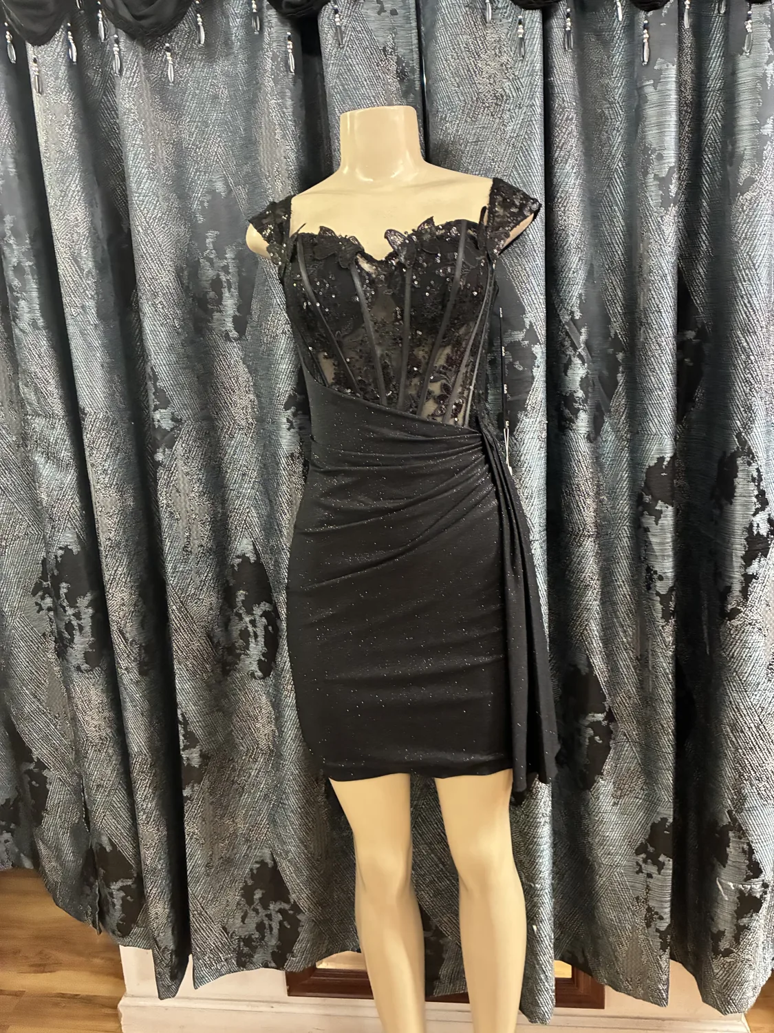 Black lace cocktail dress displayed on a mannequin