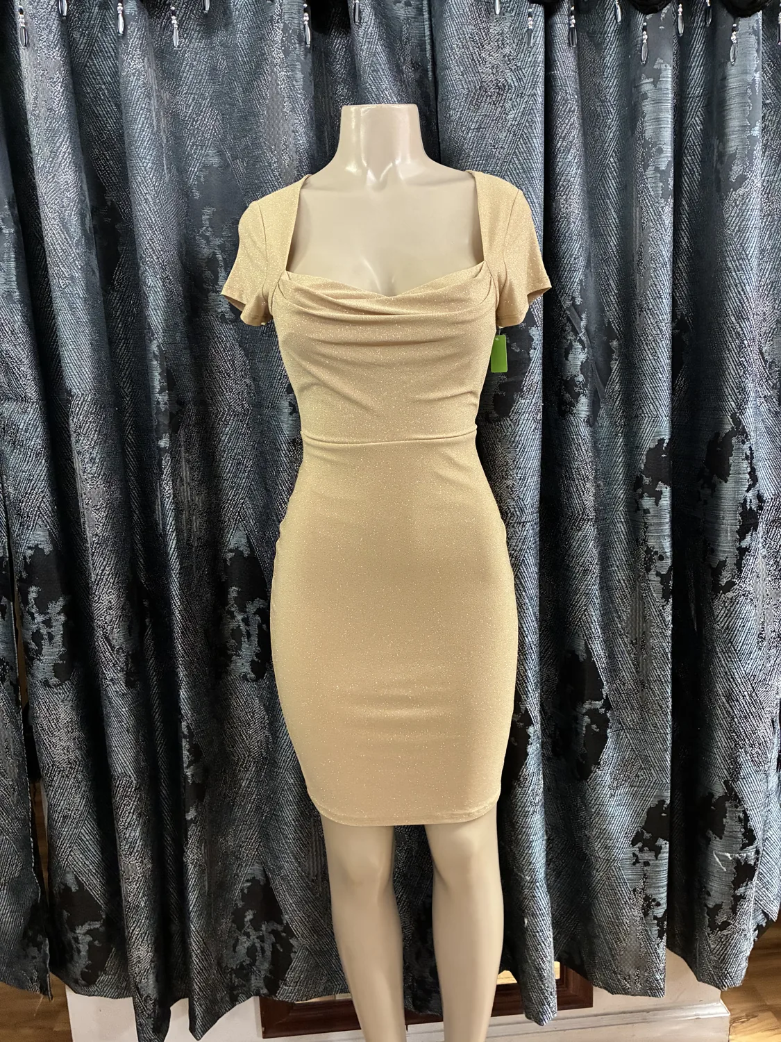Champagne draped midi dress displayed on a mannequin