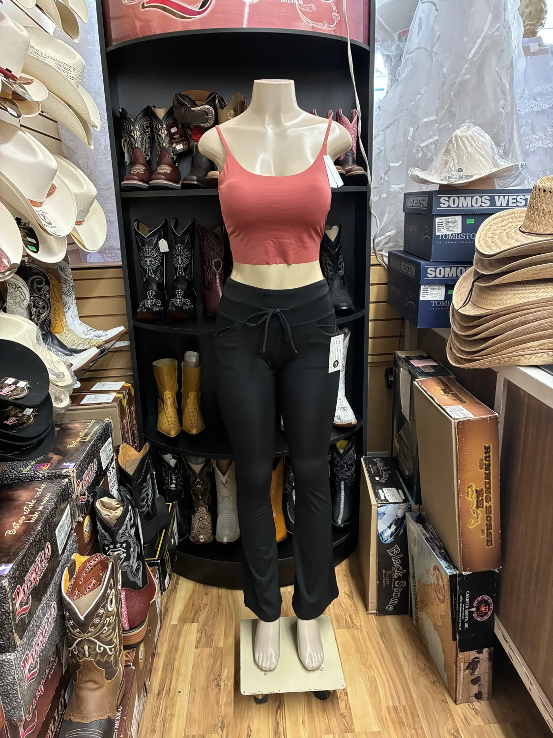 Coral top & black trousers displayed on a mannequin