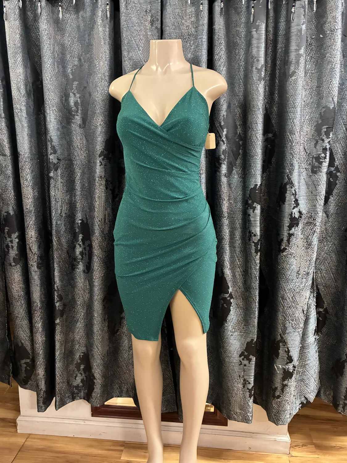 Emerald ruched cocktail dress displayed on a mannequin