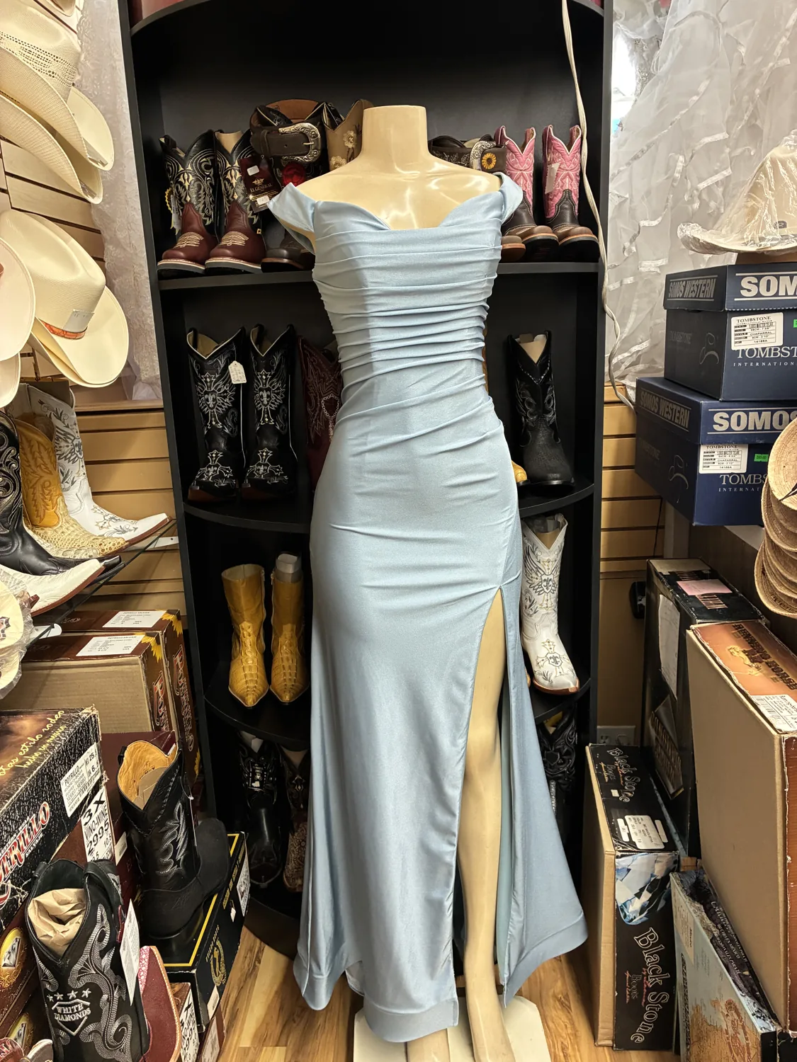 Ice-blue ruched evening gown displayed on a mannequin