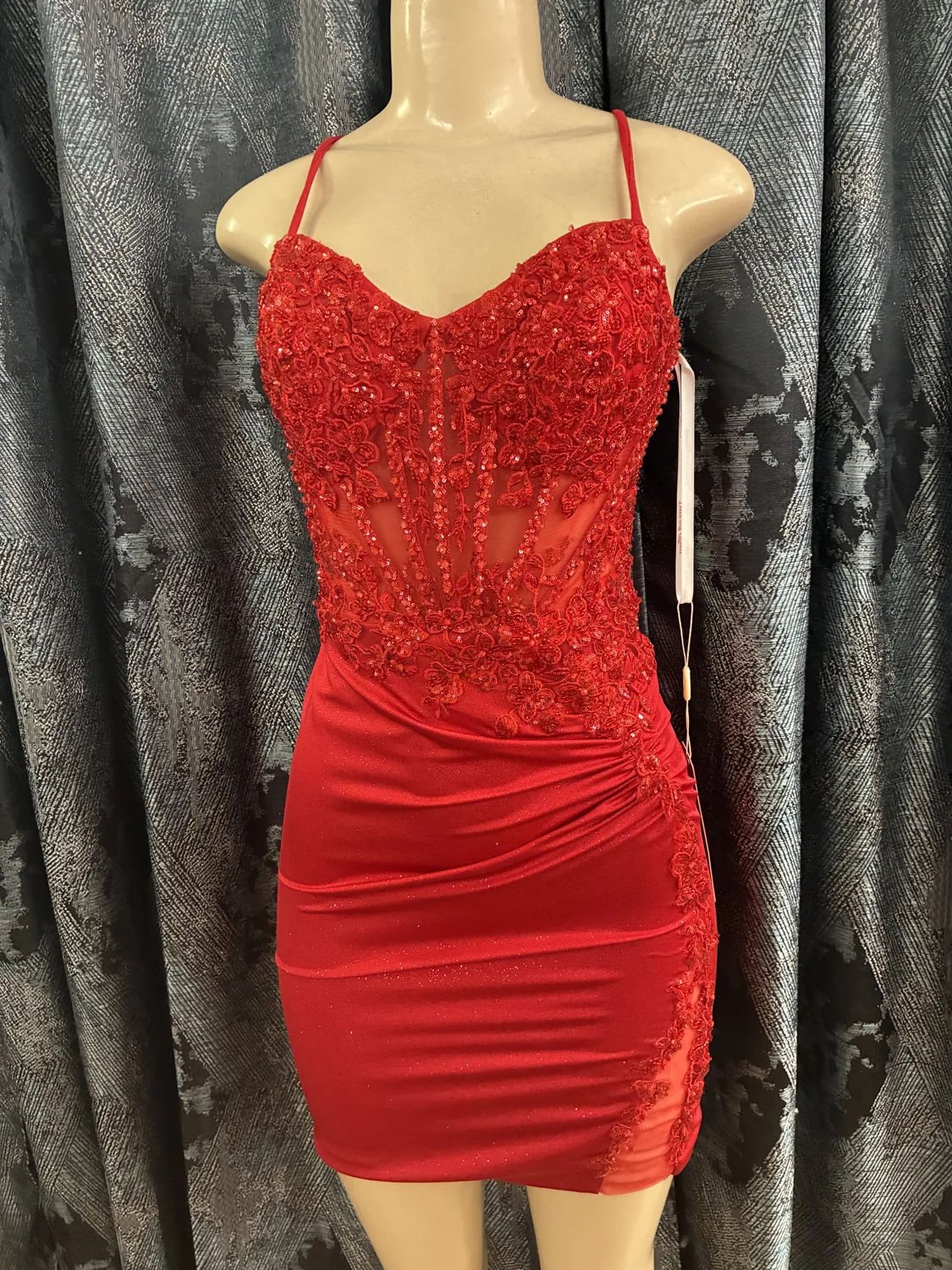Red beaded cocktail dress displayed on a mannequin