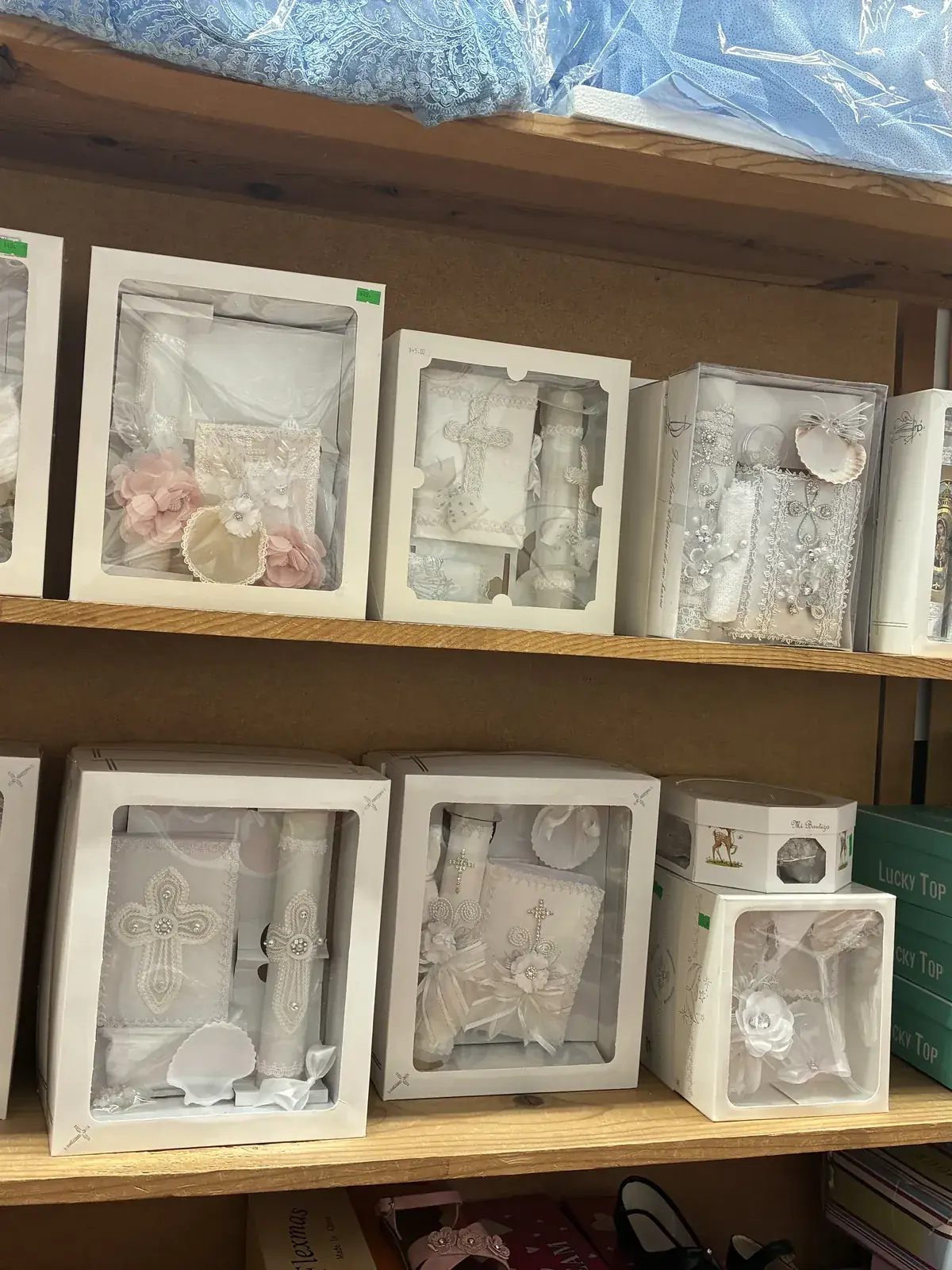 Boxed baptism & communion sets on display at Yessenia’s Fashion