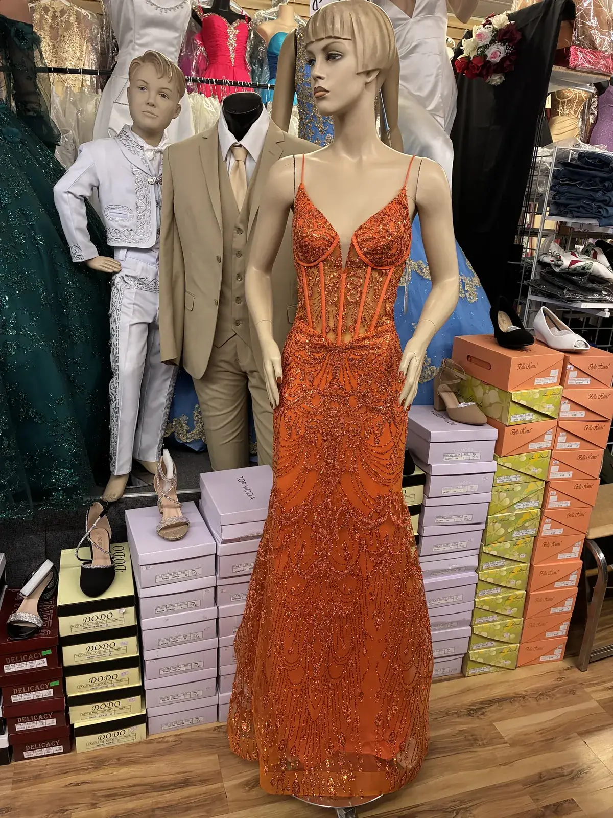 Orange beaded evening gown on display at Yessenia’s Fashion