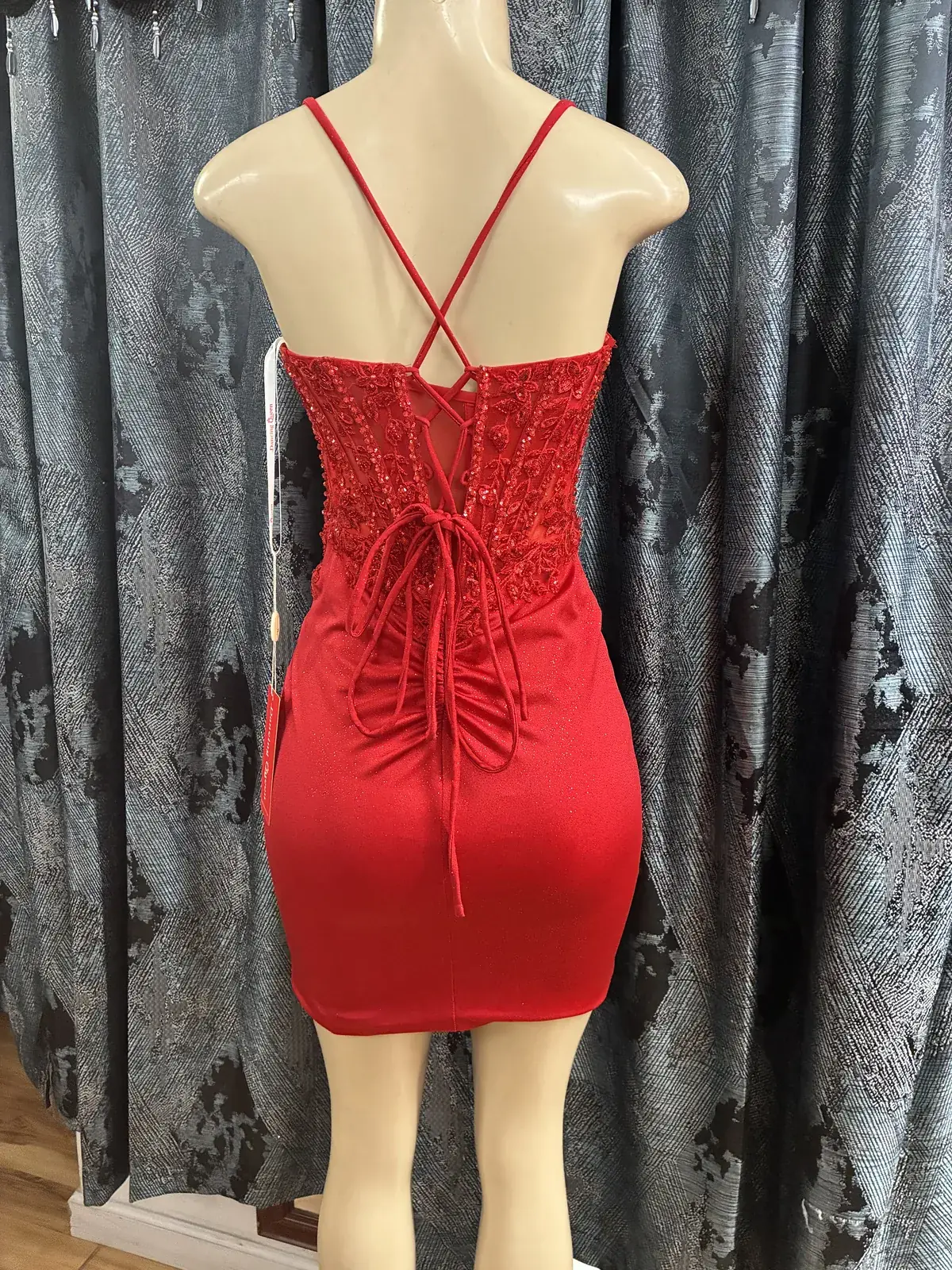 Red cocktail dress, lace-up back on display at Yessenia’s Fashion